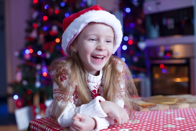 Adorable little girl baking gingerbread cookies for Christmas