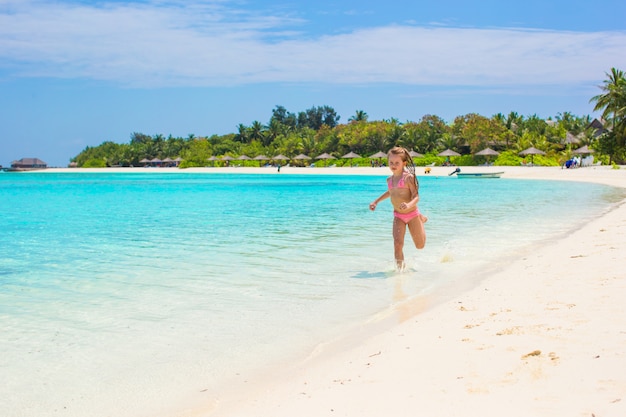 Adorable little girl at beach during summer vacation