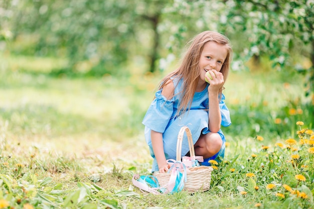 Adorable little girl in blooming apple garden on beautiful spring day