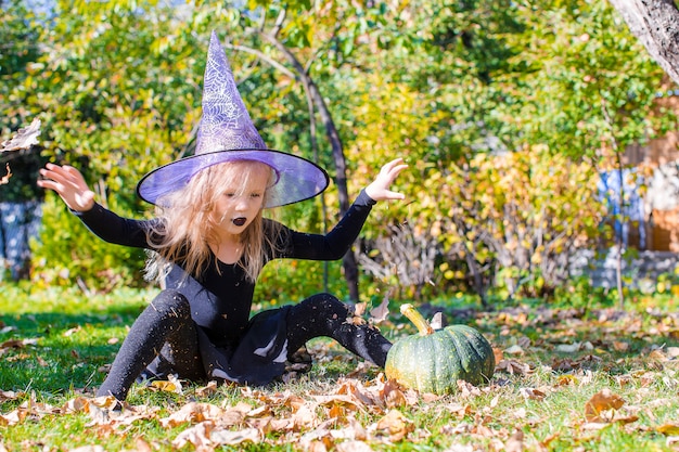 Adorable little girl in Halloween which costume having fun outdoors