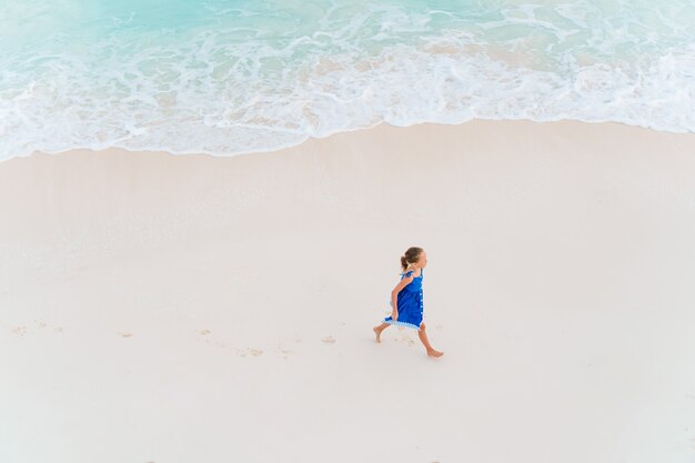 Adorable little girl have fun at tropical beach during vacation