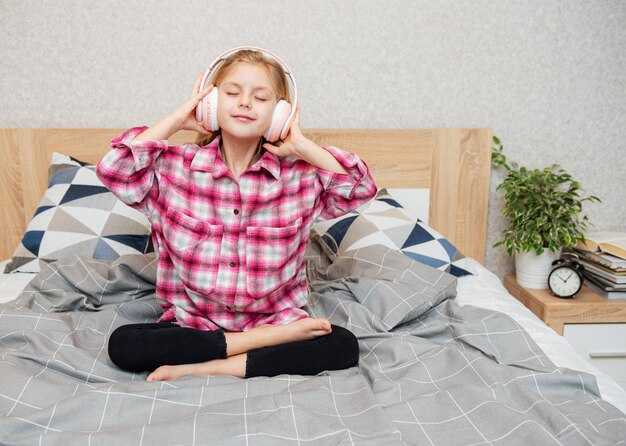 Adorable little girl in headphones enjoy with a music.