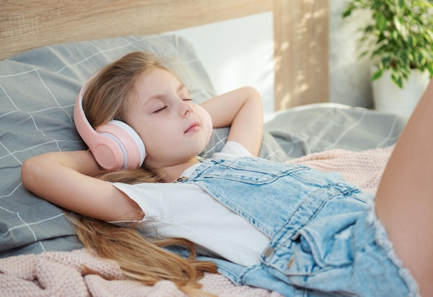 Adorable little girl in headphones enjoy with a music