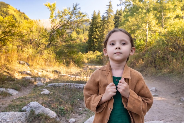 Adorable little girl hiking in the mountains outdoor forest on summer day