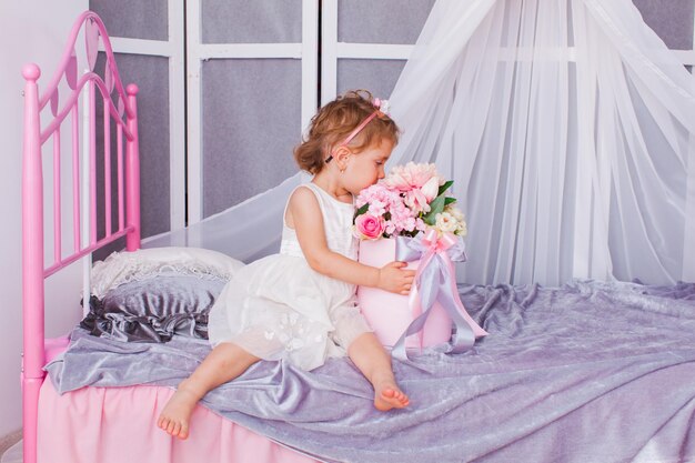 Adorable little girl holding box of flowers