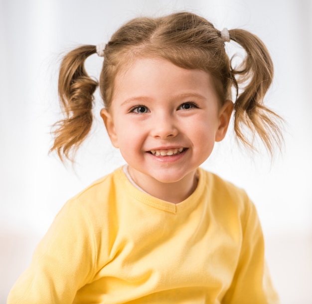 Photo adorable little girl is smiling and looking