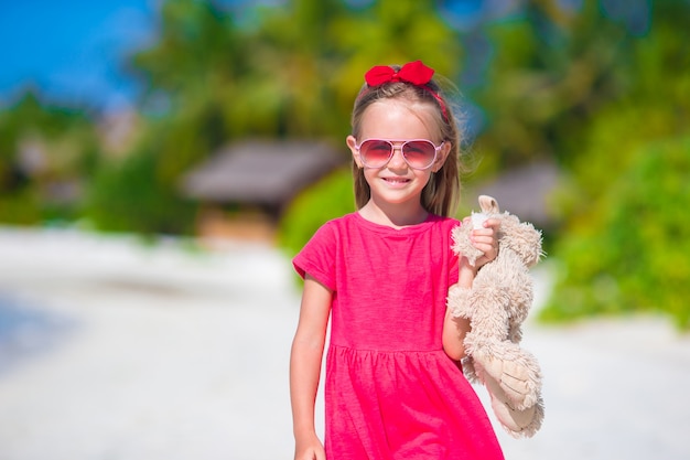 Adorable little girl playing with toy during beach vacation