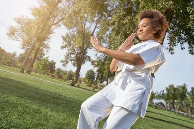 Adorable little girl practicing martial arts outdoors