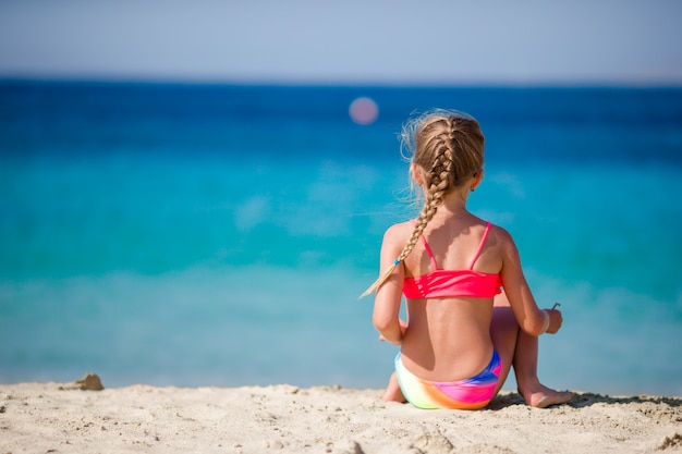 Adorable little girl at tropical beach during vacation