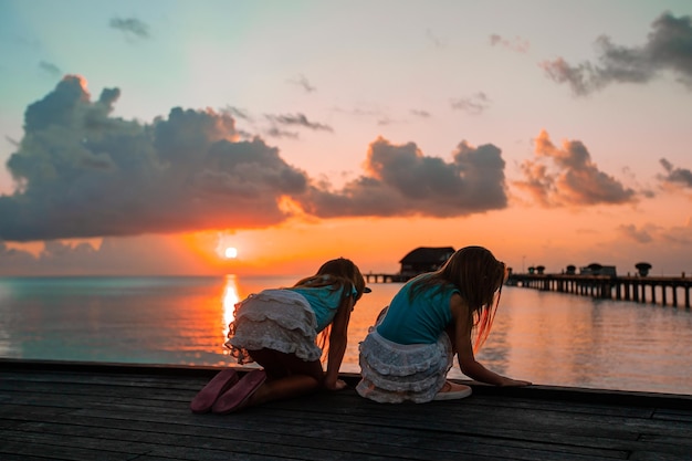 Adorable little girls on the beach at sunset