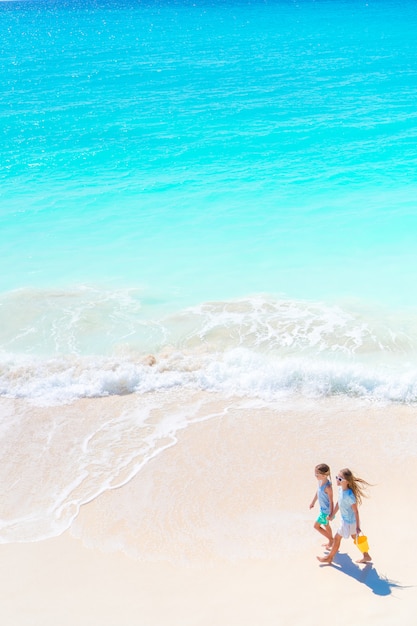 Adorable little girls on the beach. Top view of kids walking on the seashore