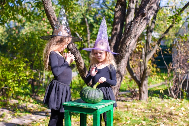 Adorable little girls in witch costume on Halloween have fun