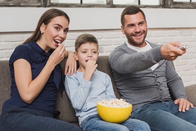 Adorable parents with son watching a movie