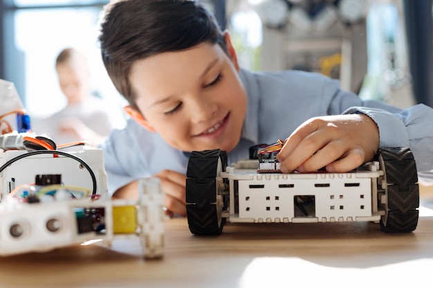 Adorable pre-teen kids inspecting robotic vehicle workshop