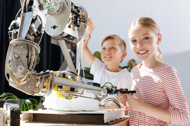 Photo adorable pre-teen kids inspecting robotic vehicle workshop