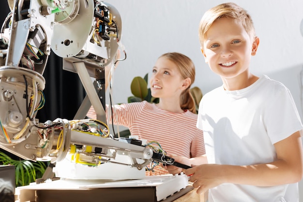 Photo adorable pre-teen kids inspecting robotic vehicle workshop