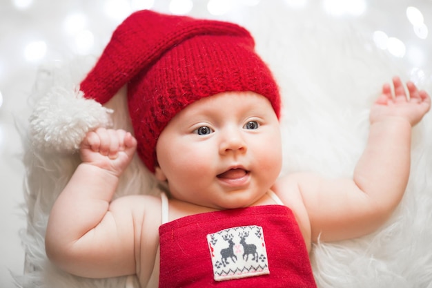 Adorable sleeping newborn baby wearing Santa Claus hat Christmas New Year