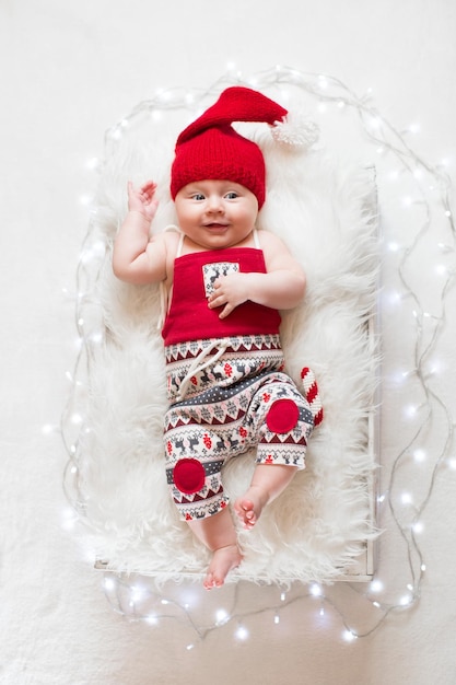 Adorable sleeping newborn baby wearing Santa Claus hat Christmas New Year