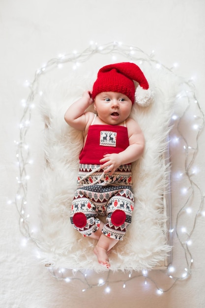 Adorable sleeping newborn baby wearing Santa Claus hat Christmas New Year