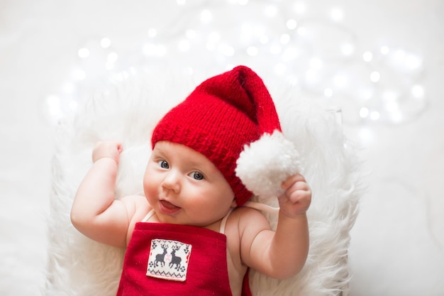 Adorable sleeping newborn baby wearing Santa Claus hat Christmas New Year