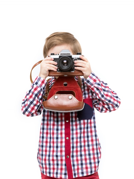 Adorable smart photographer kid holding black camera in hands