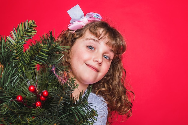 Adorable smiling girl on red background. Christmas concept.