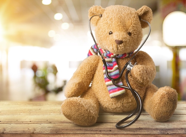 Adorable teddy bear, isolated on white, holding a stethoscope.