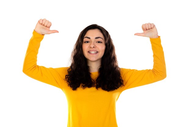 Adorable teenage girl with yellow sweater isolated on a white wall