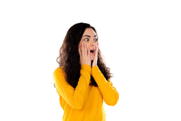 Adorable teenage girl with yellow sweater isolated on a white wall