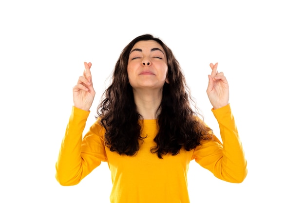 Adorable teenage girl with yellow sweater isolated on a white wall