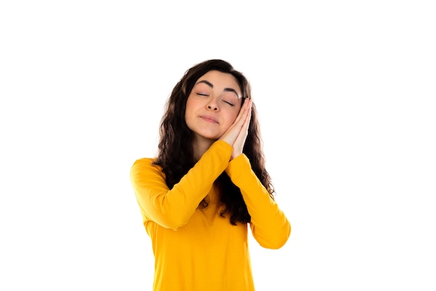 Adorable teenage girl with yellow sweater isolated on a white wall