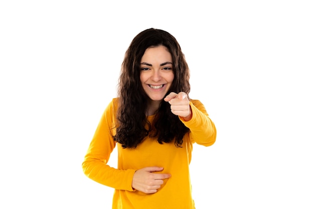 Adorable teenage girl with yellow sweater isolated on a white wall