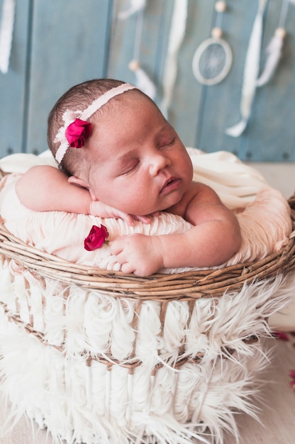 Adorable tiny baby sleeping in basket