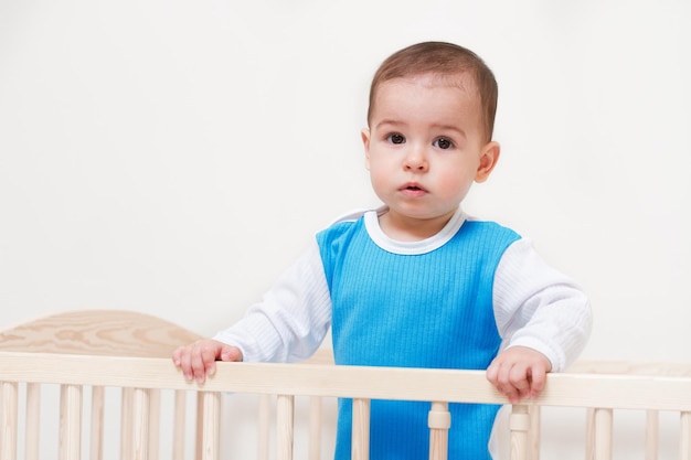 Adorable toddler baby in the bed look at camera on white background