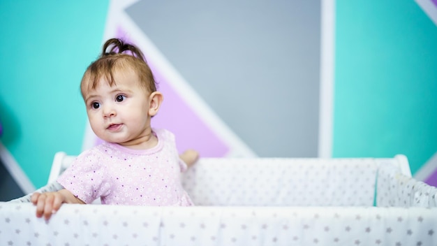 Adorable toddler peeking out from crib