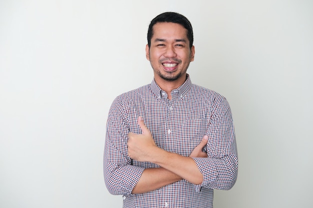 Adult Asian man crossed his arms and smiling while giving thumb up