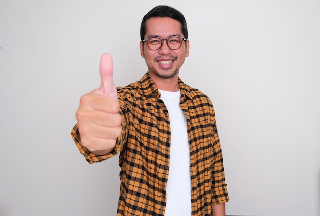 Adult Asian man smiling happy at the camera and give thumb up