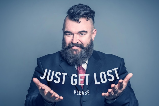 Adult bearded man in a suit holding the inscription JUST GET LOST PLEASE