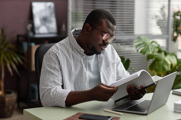 Adult black man wearing glasses at workplace in casual office