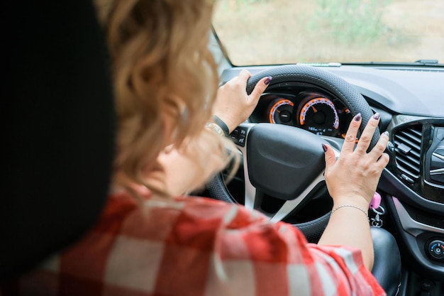 Adult blonde woman driving a car inside view