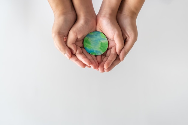 Adult and child hands holding the earth on hand