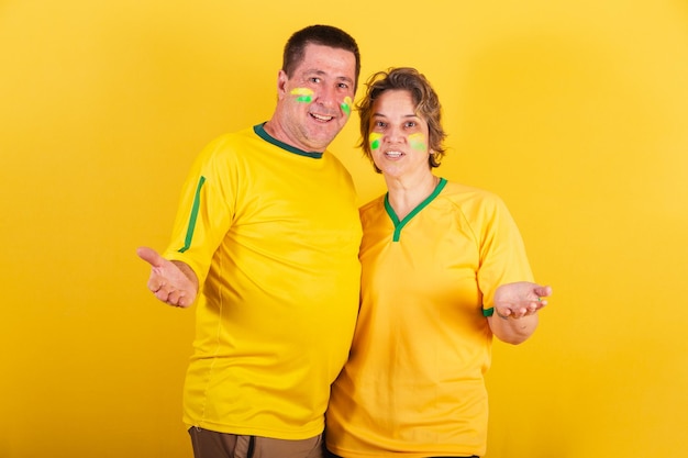 Adult couple soccer fans from Brazil with open arms welcome