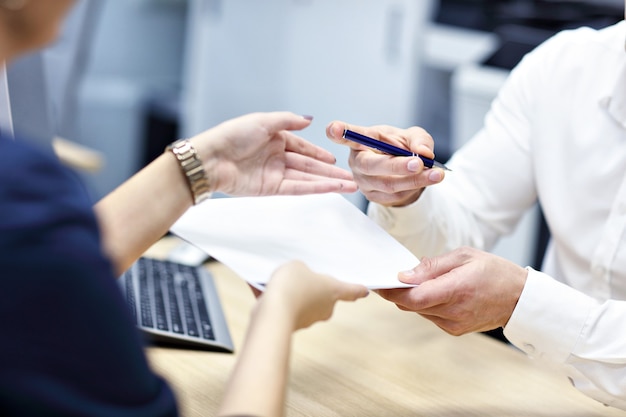 adult hands holding documents and pen