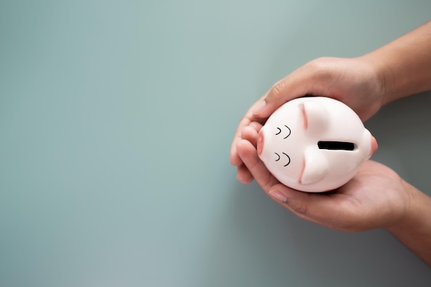 Adult hands holding a piggy bank in savings concept