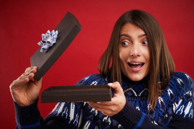 Adult happy woman with Christmas gift over green background