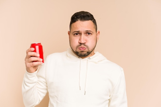 Adult latin man drinking cola refreshment isolated