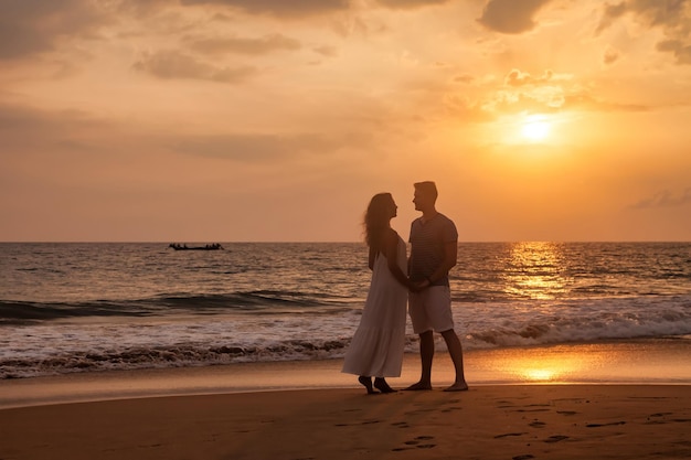 Adult lovely family couple holding hands look at each other at ocean sunset background Man and woman in casual clothes walking together sandy beach outdoor