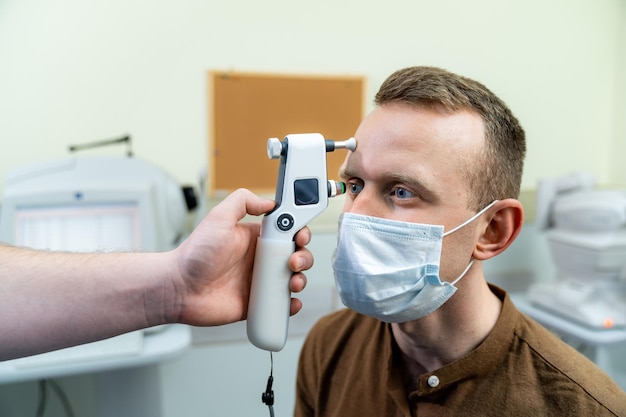 Adult man checks eyesight with binocular slitlamp Checking retina of a male eye closeup Modern ophthalmology clinic