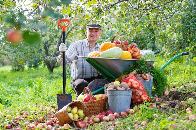 Adult man in the garden with a rich harvest