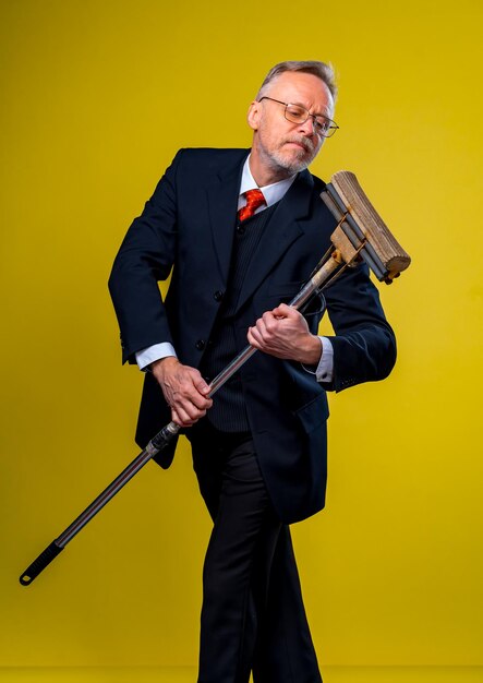 Adult man singing in mop Holding mop like microphone Man in suit